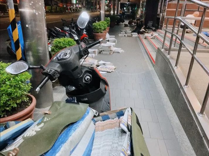 清晨騎樓下的送報機車與分裝中的報紙(示意圖)